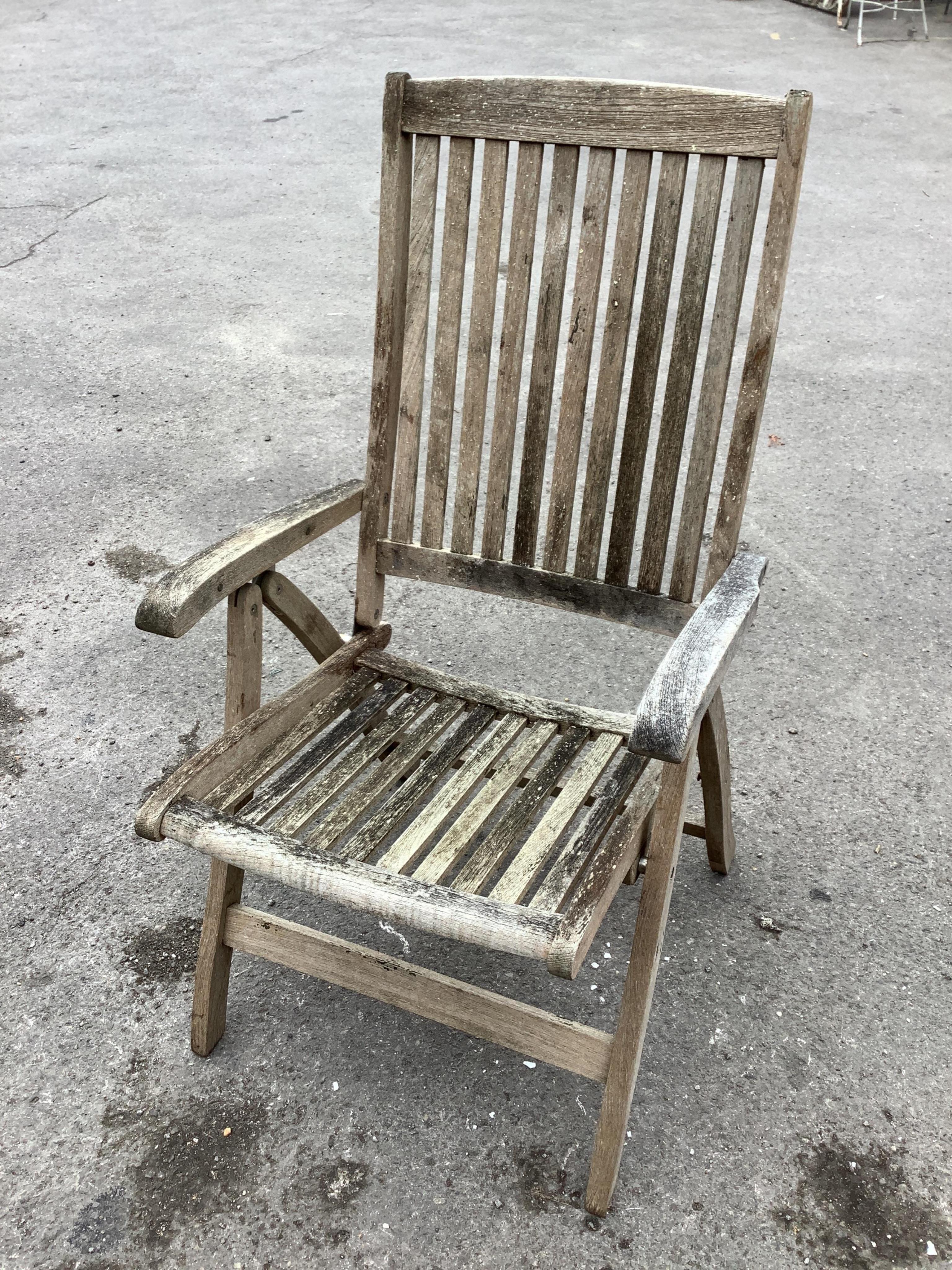 A weathered teak oval extending garden table, width 239cm extended, depth 109cm, height 73cm together with six Neptune weathered teak folding reclining garden armchairs with five Neptune cushions